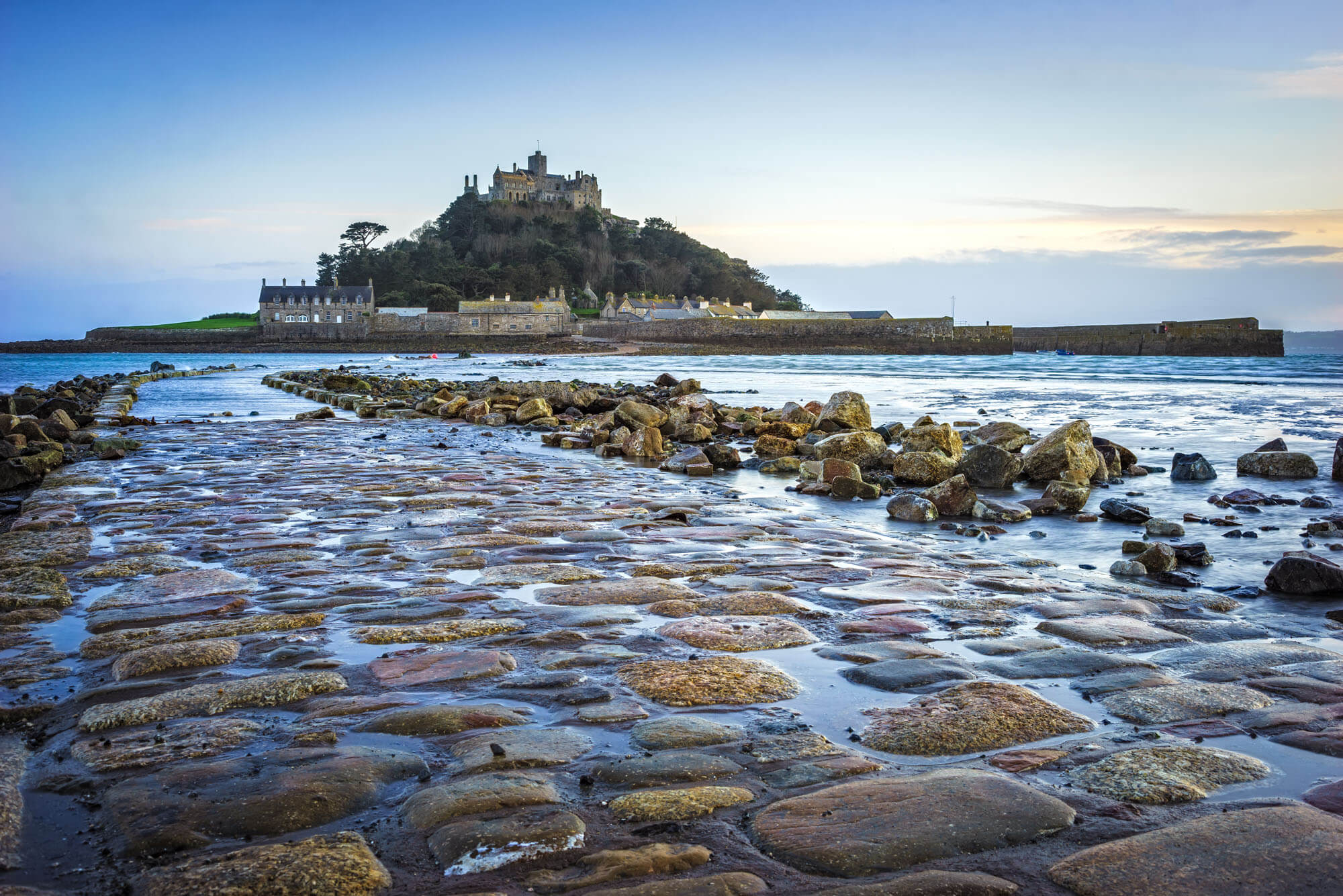 St Micheals mount road, half covered by the tide, with the island in the background showing off the beautiful buildings and remote location.